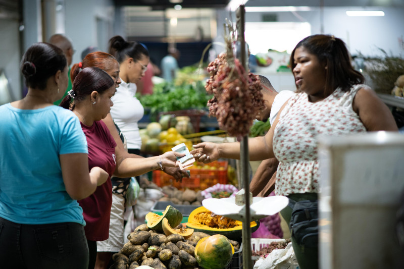 Personas compran alimentos de primera necesidad en un mercado del Distrito Nacional.