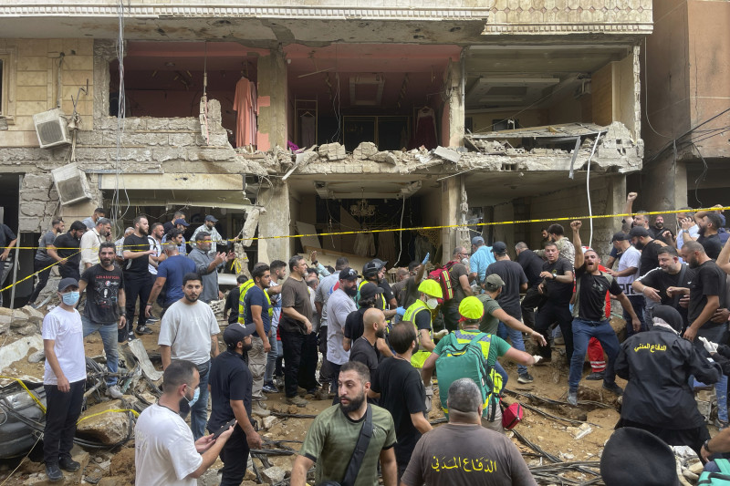 La gente se reúne cerca de un edificio dañado por un bombardeo de Israel en el sur de Beirut, Líbano, el viernes 20 de septiembre de 2024.