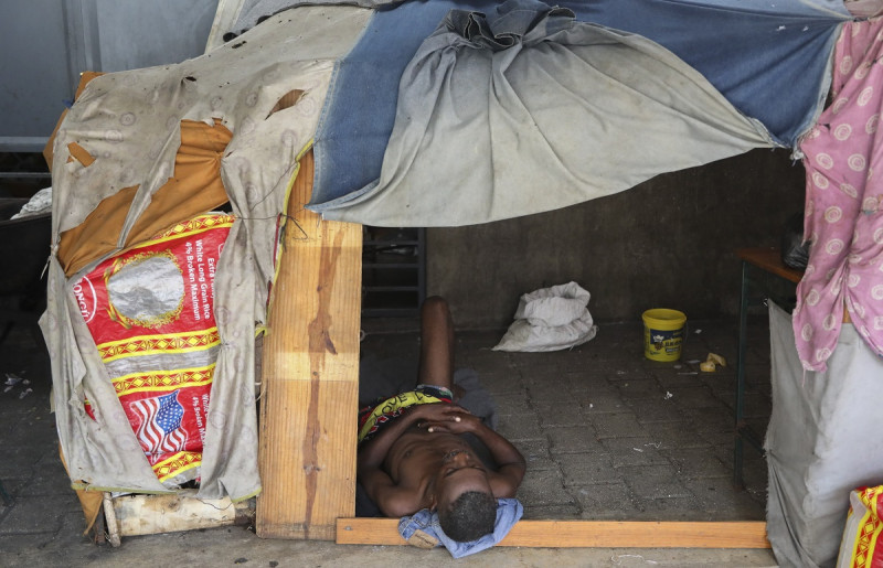 Un hombre descansa en el interior de un refugio improvisado construido dentro de una escuela pública que sirve como lugar seguro para los desplazados por la violencia pandillera en Puerto Príncipe,el 13 de septiembre de 2024.