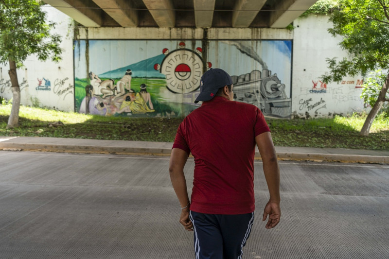 Ulises Martínez, un antiguo estudiante de la escuela Normal Rural Raúl Isidro Burgos, camina por debajo del puente donde dos de los autobuses en los que se movilizaban los estudiantes que luego desaparecieron fueron atacados hace 10 años.