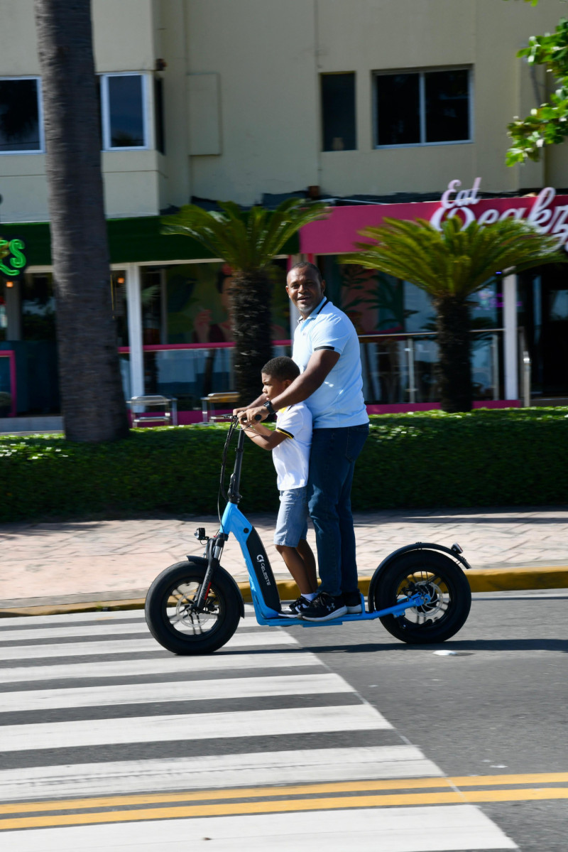 Un padre con su hijo montado patineta