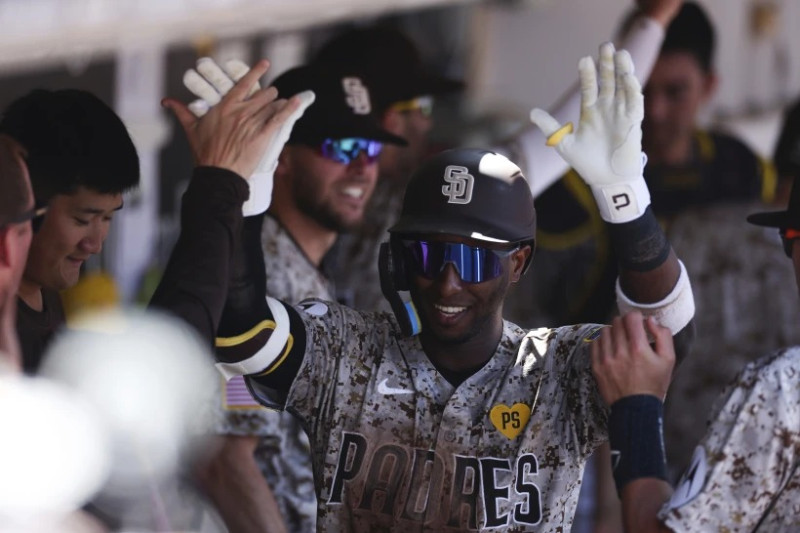 Jurickson Profar, centro, de los Padres de San Diego, es felicitado en el dugout después de conectar un jonrón solitario contra los Medias Blancas de Chicago en la tercera entrada.