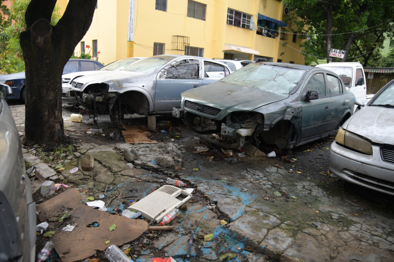 Unidades de vehículos chatarras en aceras de la avenida Cayetano Germosén retirados por el ADN en un operativo.