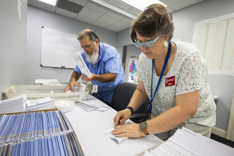 Dawn Stephens y Duane Taylor preparan boletas para votar que serán enviadas por correo postal, en la Junta Electoral del condado Mecklenburg, en Charlotte, Carolina del Norte, el 5 de septiembre de 2024.