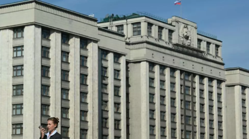 Una mujer pasa frente al gran edificio sede la Duma, la cámara baja del Parlamento ruso, el 24 de septiembre de 2024 en el centro de Moscú.