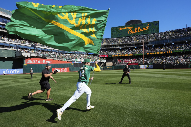 Max Schuemann, de los Atléticos de Oakland, corre con una bandera del equipo después del último partido de los Atléticos en Oakland, el jueves 26 de septiembre de 2024