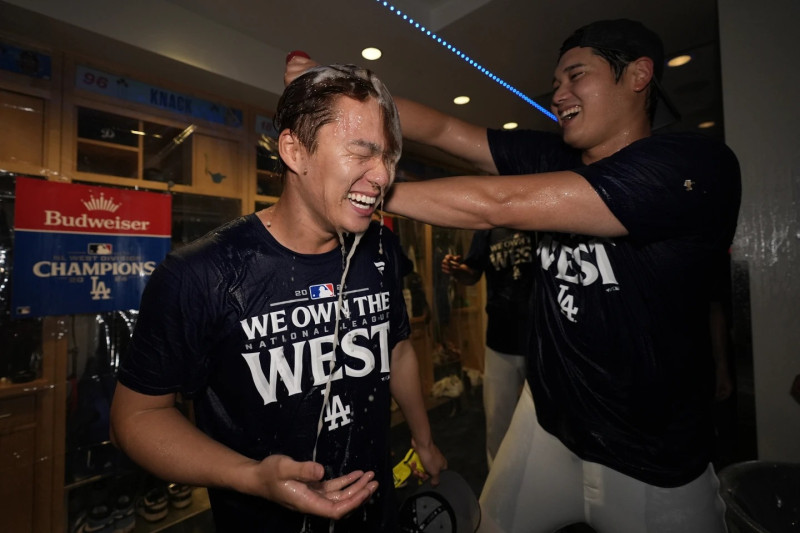 Shonei Ohtani baña de champaña a su compañero Yoshinobu Yamamoto luego que los Dodgers aseguraron el banderín de la División Oeste de la Liga Nacional.