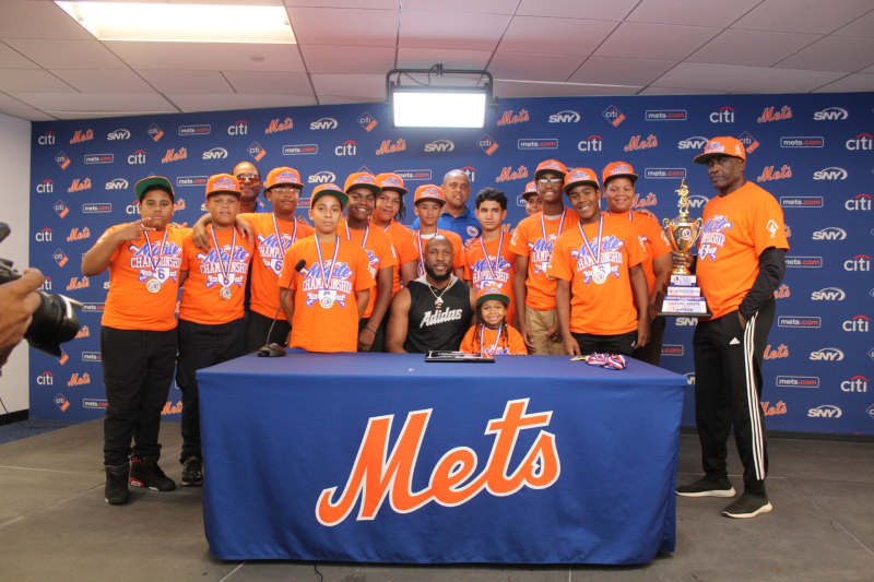 El jardinero derecho de los Mets, Starling Marte, (sentado), y el empresario Roberto Rojas, premiaron a los campeones 11-12 años, en acto celebrado en sala de conferencias en Citi Field.