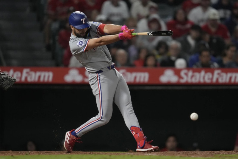 Jonathan Ornelas, de los Rangers de Texas, pega un sencillo en el noveno inning del juego ante los Angelinos de Los Ángeles.