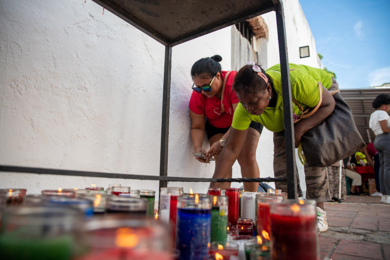 Seguidores de San Miguel encienden velas con motivo a la celebración.