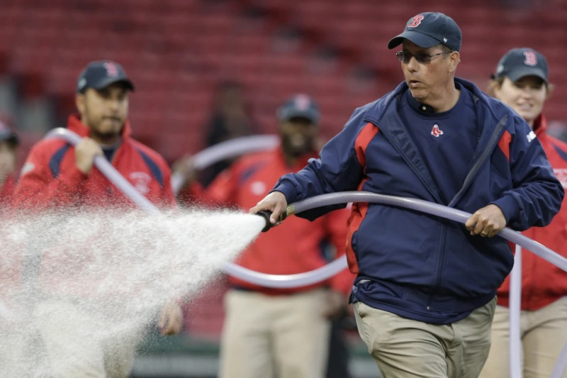 Dave Mellor, jardinero de los Medias Rojas de Boston, riega el campo antes de un partido de béisbol en el Fenway Park de Boston, el 28 de abril de 2016.