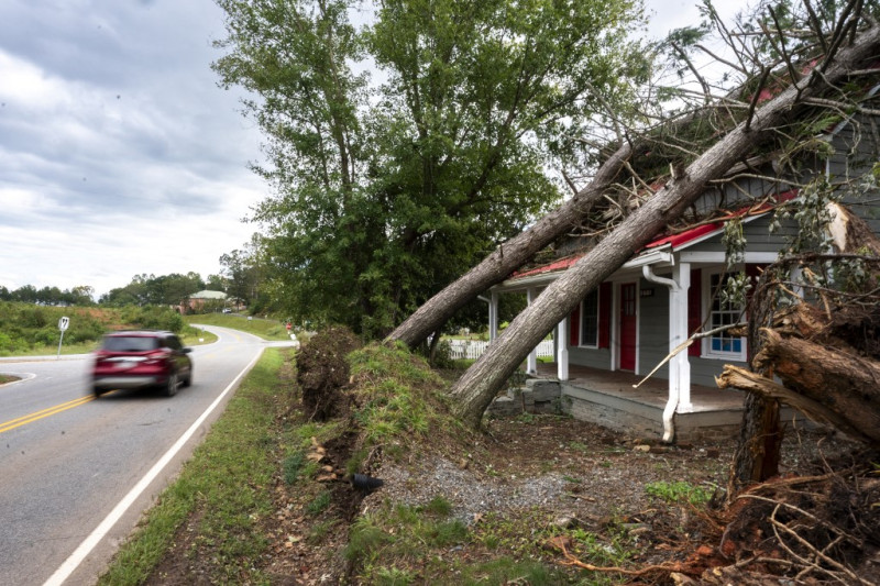 Un automovilista pasa junto a una casa con árboles caídos en el techo después del huracán Helene el 29 de septiembre de 2024 en Rutherfordton, Carolina del Norte.