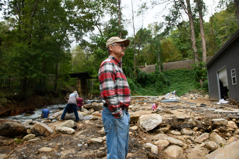 Un hombre mira hacia su propiedad donde perdió un taller recientemente construido y un puente que construyó después del huracán Helene el 30 de septiembre de 2024 en Old Fort, Carolina del Norte.