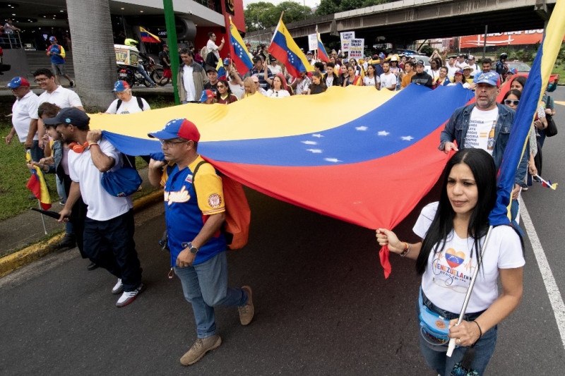 La gente marcha con una bandera venezolana durante una manifestación para protestar contra las elecciones presidenciales venezolanas del 28 de julio en San José, Costa Rica, el 28 de septiembre de 2024.