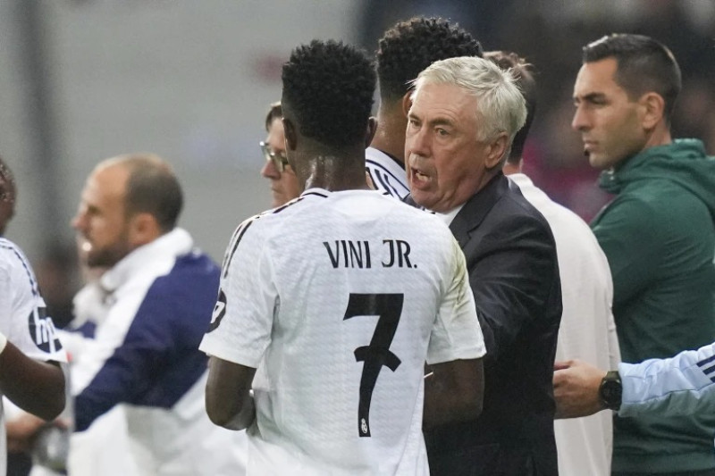 El entrenador del Real Madrid, Carlo Ancelotti, habla con Vinicius Junior durante el partido de apertura de la Liga de Campeones entre Lille y Real Madrid.