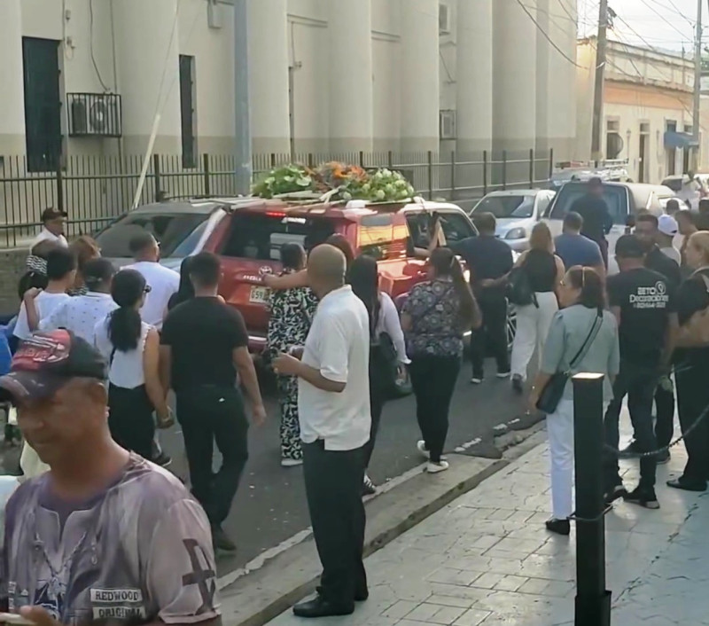 El carro fúnebre con el cuerpo de Raffy Matías cuando iba por una de las calles de La Vega camino al cementerio.