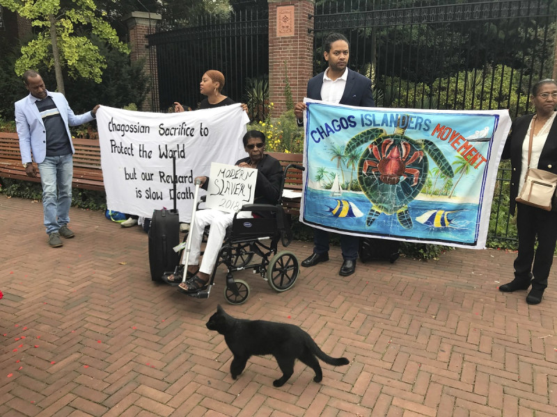 Manifestantes sostienen carteles ante la Corte Mundial en La Haya, Holanda, el lunes 3 de septiembre de 2018,  donde los jueces escuchan argumentos en un caso sobre si Reino Unido mantiene una soberanía ilegal sobre las islas Chagos.