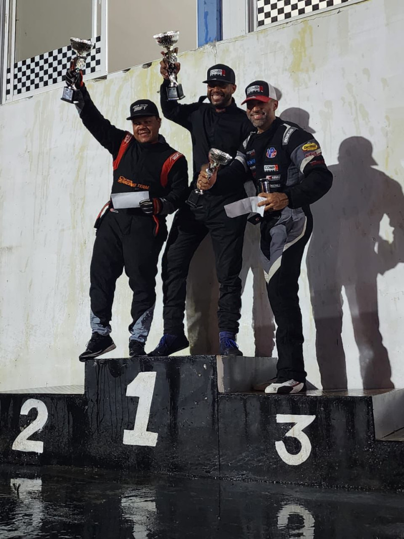 Los pilotos Rafael Adames, Franklyn Castro y Omar Castellanos exhiben sus trofeos en el momento de la premiación.