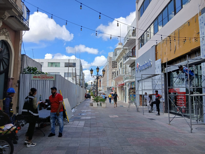 A la izquierda, el parqueo de la calle El Conde con José Reyes, cerrado por fallas estructurales en 2021, tres años después, todavía esta en etapa de construcción.