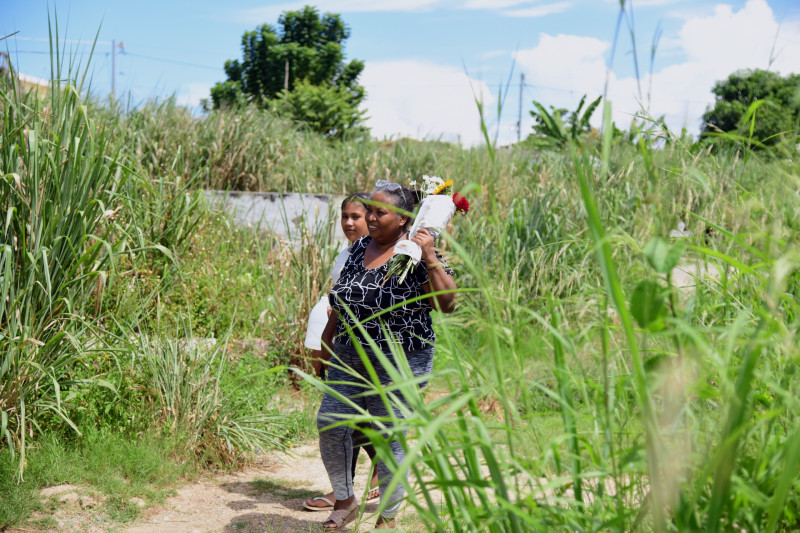 Fotografía muestra a Ramona Peralta quien camina con una flores en la mano rumbo a dejárselas a su madre en el Cementerio Cristo Redentor.