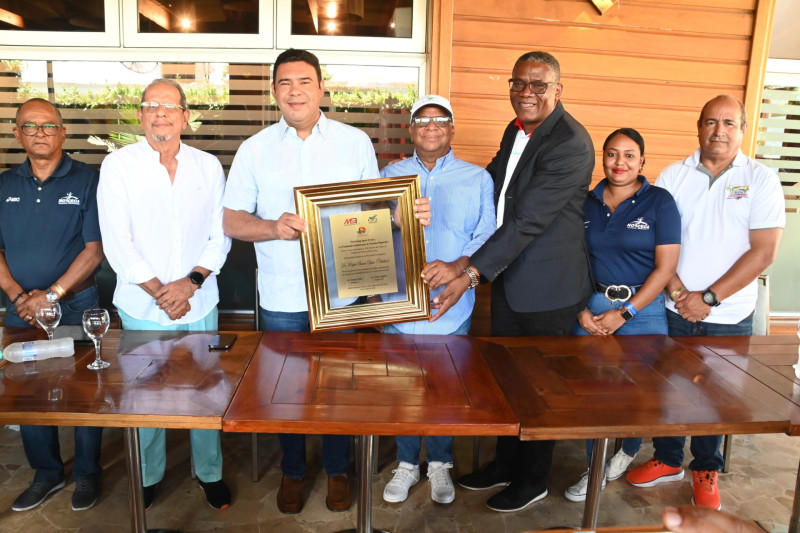 El senador por la provincia La Altagracia, Rafael Barón Duluc (Cholitin), recibe una placa de conocimiento de las manos de Amós Anglada, presidente del proyecto de voleibol de playa de la Fedovoli; Ernesto Veloz, presidente de la Asociación de Hoteles y Proyectos Turísticos en la Zona.