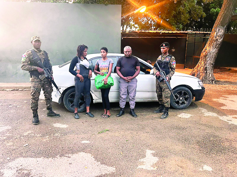 Dos miembros del Ejército custodian al capitán Roberto Brito y a dos mujeres indocumentadas haitianas a quienes transportaba, vestido en uniforme policial, a través del municipio Ranchadero.