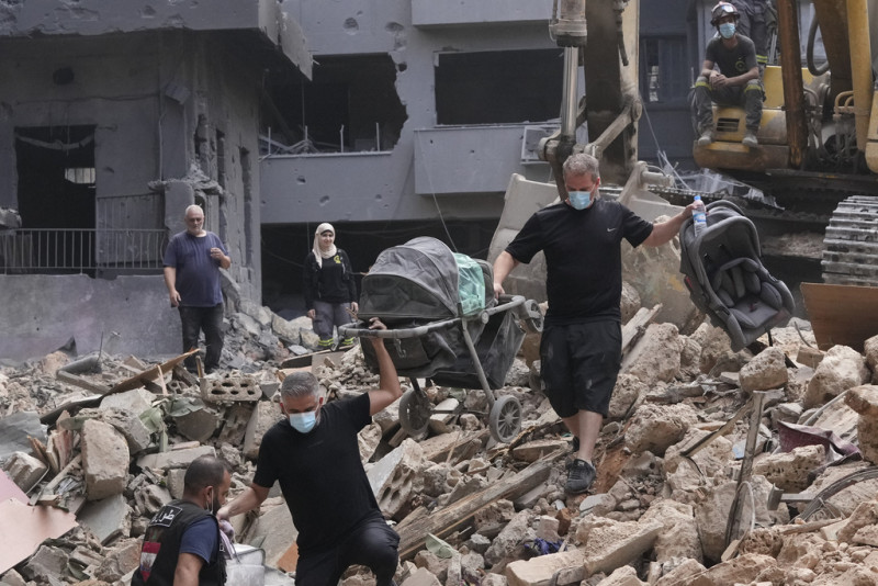 Residentes de un edificio dañado por un ataque aéreo israelí vuelven para recoger las pertenencias de su familia en Beirut, Líbano, el sábado 12 de octubre de 2024