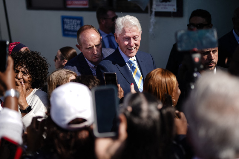 El ex presidente estadounidense Bill Clinton estrecha la mano y posa para fotografías con sus seguidores después de hablar en nombre de la campaña Harris/Walz frente a una oficina de campaña demócrata el 14 de octubre de 2024 en Columbus, Georgia.