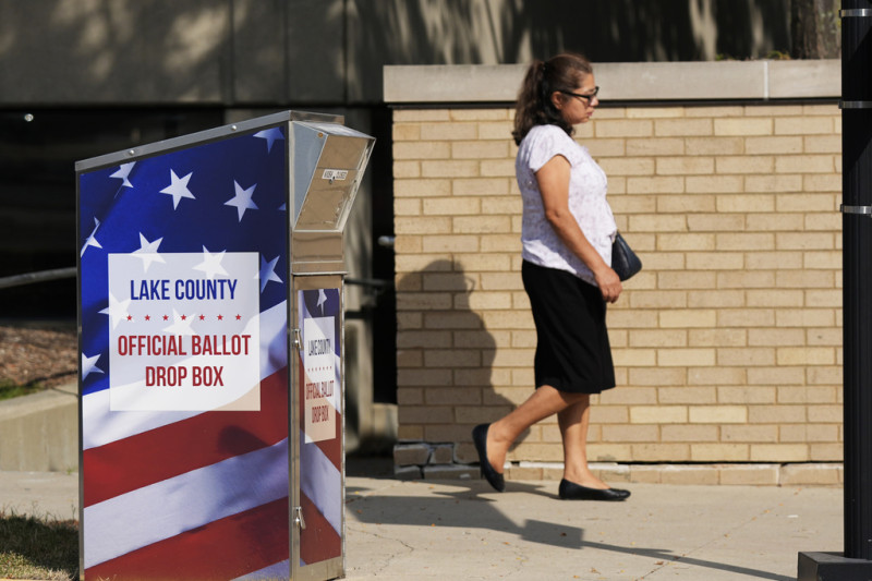 Una persona pasa por delante de un buzón de votos para el condado de Lake en el centro de Waukegan, Illinois, el lunes 16 de septiembre de 2024