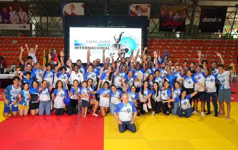 Los judocas, entrenadores, dirigentes y directivos del Club Naco celebran con sus trofeos y medallas en manos haber ganado la Copa Internacional Judo Naco 2024.