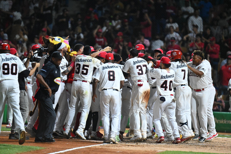 Jugadores de los Leones del Escogido celebran en el home luego del jonrón de oro de Junior Lake.