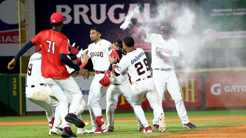 Los jugadores de los Leones celebran con Erik González luego de su hit de oro.