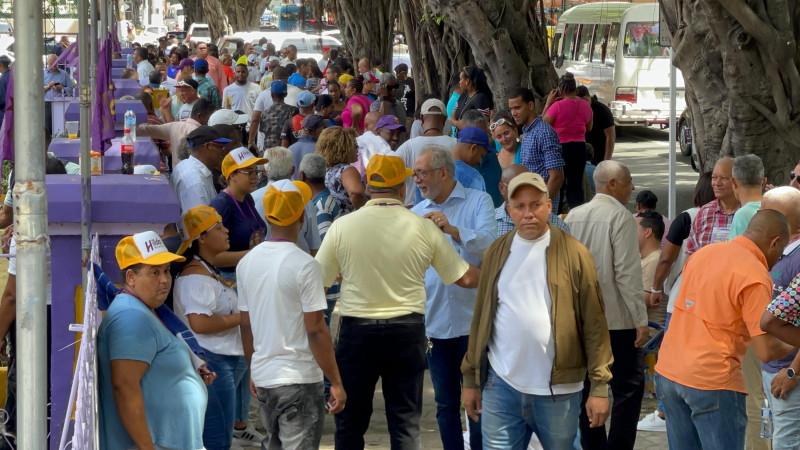 Militantes del Partido de la Liberación Dominicana se reúnen en las afueras de la Casa Nacional del partido durante el proceso de votación.