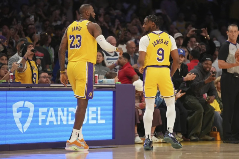 LeBron James, de los Lakers de Los Ángeles, y su hijo Bronny, caminan en la cancha durante el encuentro del martes 22 de octubre de 2024, ante los Timberwolves.