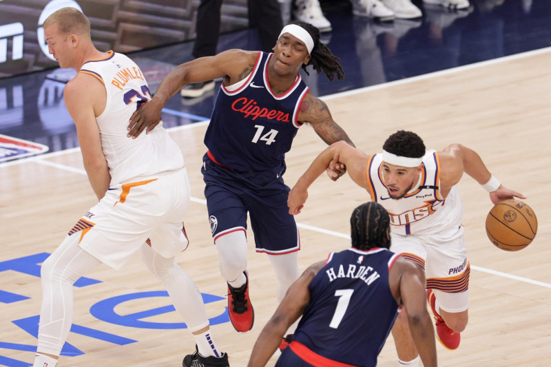 Devin Booker, de los Suns, intenta superar la defensa de Terrance Mann, de los Clippers, en acción del partido de la NBA el miércoles por la noche.