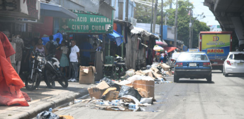 Los comerciantes obstruyen con casetas y mercancías el paso peatonal por las aceras.