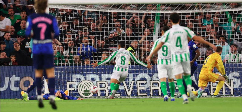 José Giménez (en el suelo) marca un gol en propia puerta durante el partido de LaLiga entre el Real Betis Balompié y el Atlético de Madrid.