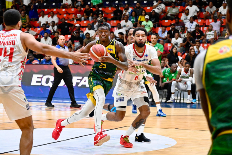 Michael Warren, de San Carlos, avanza con el balón ante la defensa de JJ Romer, de Bameso.