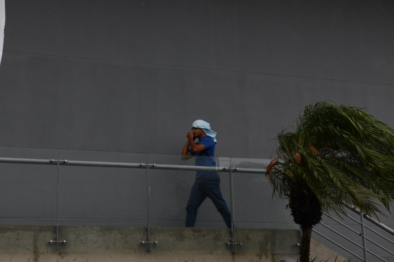 Un hombre se cubre con una toalla mientras llueve en el Distrito Nacional.