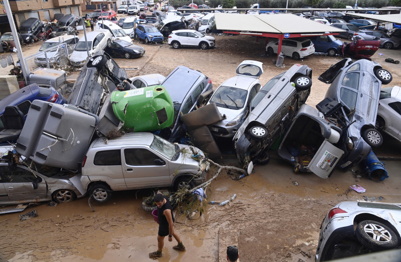 Wreckage of cars and debris are piled up in the streets of Paiporta, on October 31, 2024, covered in mud after flash floods ravaged this area of Valencia region, eastern Spain. - Rescuers raced on October 31, 2024 to find survivors and victims of once-in-a-generation floods in Spain that killed at least 95 people and left towns submerged in a muddy deluge with overturned cars scattered in the streets. About 1,000 troops joined police and firefighters in the grim search for bodies in the Valencia region as Spain started three days of mourning. Up to a year's rain fell in a few hours on the eastern city of Valencia and surrounding region on October 29 sending torrents of water and mud through towns and cities. (Photo by JOSE JORDAN / AFP)