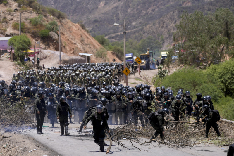 La policía despeja una carretera bloqueada por partidarios de Evo Morales, para evitar que enfrente una investigación penal por acusaciones de abuso de una menor