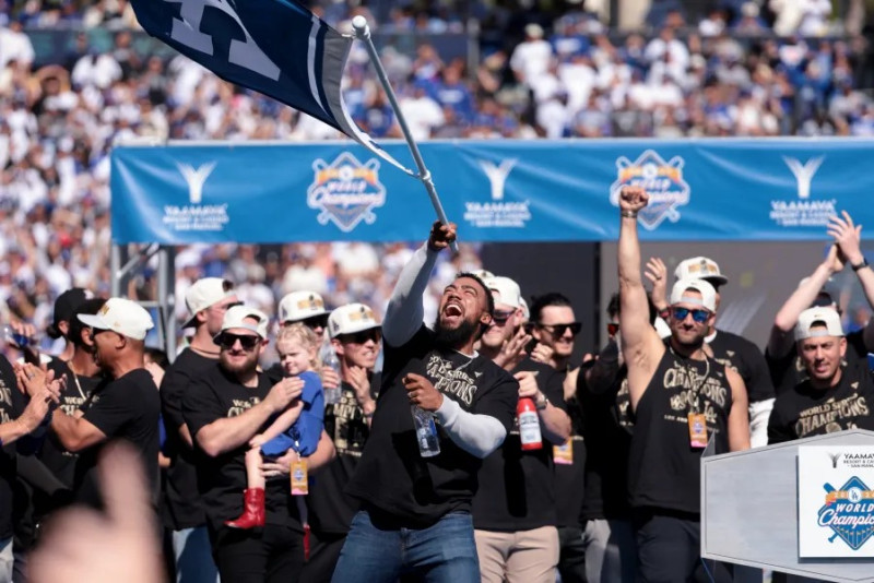 Teoscar Hernández portando una bandera durante la celebración de los Dodgers del cetro alcanzado en la Serie Mundial ante los Yankees