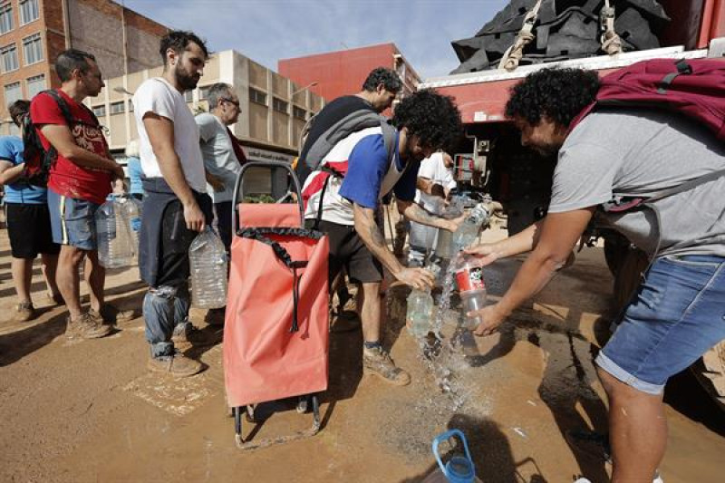 Vecinos de Paiporta recogen agua potable de un camión de la UME, este jueves. La Comunitat Valenciana intenta recuperarse de la peor dana del siglo en España, que ha dejado casi un centenar de muertos en esa región, además de un inmenso escenario de daños en carreteras, calles e infraestructuras de numerosas localidades.