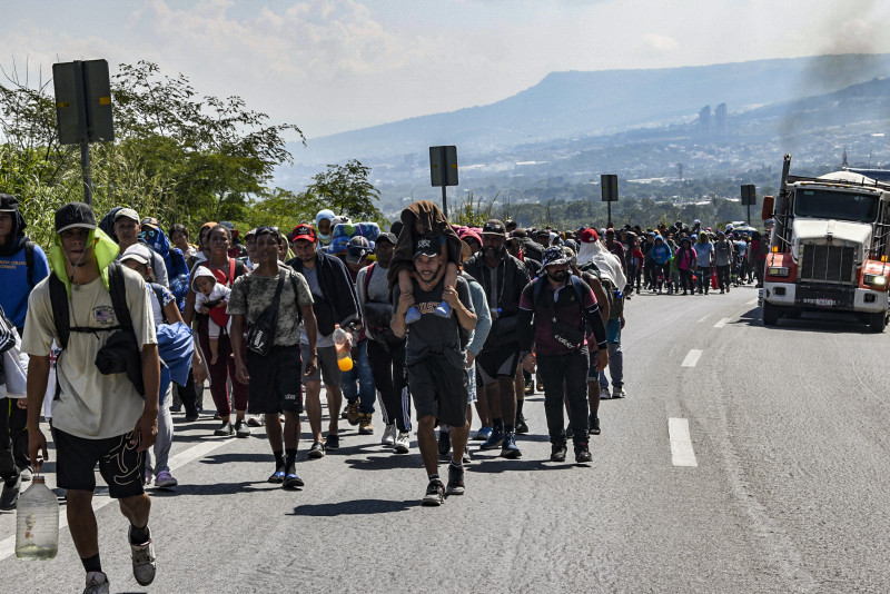 Migrants of different nationalities walk to the United States in a caravan along a highway in Tuxtla Gutierrez, Chiapas State, Mexico, on November 5, 2024. (Photo by Isaac GUZMAN / AFP)