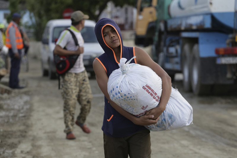 Un niño camina con donaciones luego de que el huracán Oscar