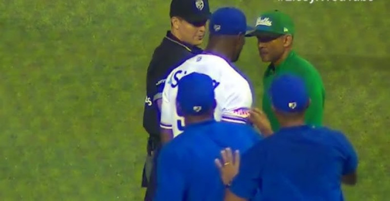 Radhames Liz, lanzador del Licey al momento de interpelar a Fernando tatis, dirigente de las Estrellas, quien había reclamado que el pitcher tenía una manga rasgada en su camiseta.