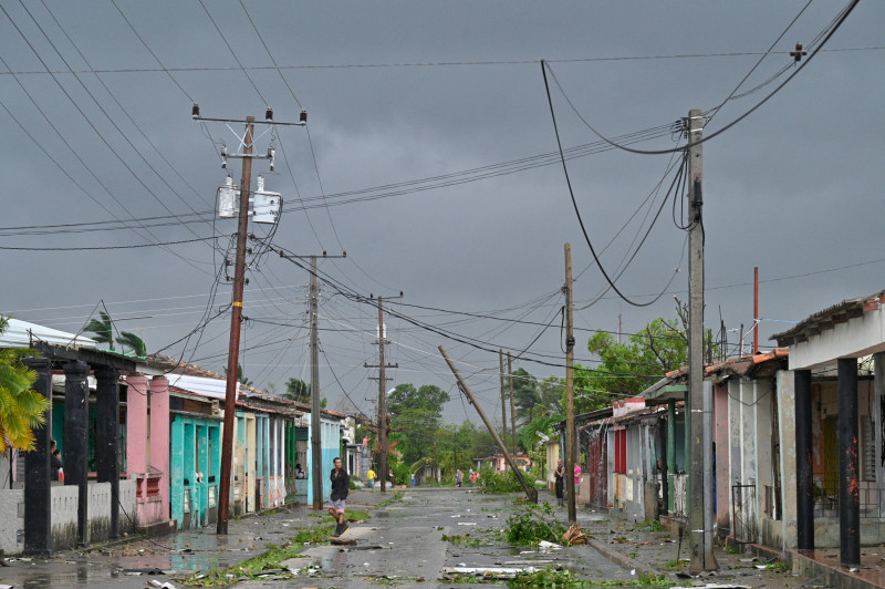 A man walks on a street during the pass of the Hurricane Rafael's eye in Pueblo Candelaria, Artemisa Province, 65 km west of Havana, on November 6, 2024. - Hurricane Rafael knocked out power to all of Cuba on Wednesday as it made landfall on the island still reeling from a recent blackout and a previous major storm, the national power company said. (Photo by ADALBERTO ROQUE / AFP)