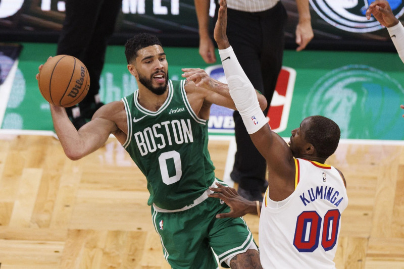 Jayson Tatum, de los Celtics, intenta pasar el balón ante la defensa de Jonathan Kuminga, de los Warriors, en el partido del miércoles en el baloncesto de la NBA.