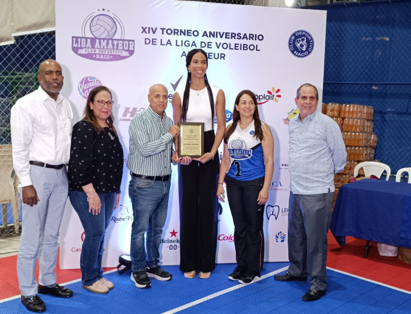 La secretaria general del Club Naco, Madelaine Andino, junto a otros miembros de la Junta Directiva, entrega un reconocimiento a Geraldine González.