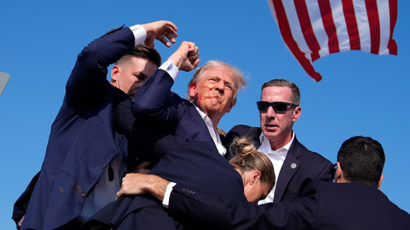 La histórica fotografía de Trump con su rostro ensangrentado, la bandera estadounidense ondeando en sus espaldas y su brazo alzado, al tiempo de vociferar: “!Luchar, luchar!”